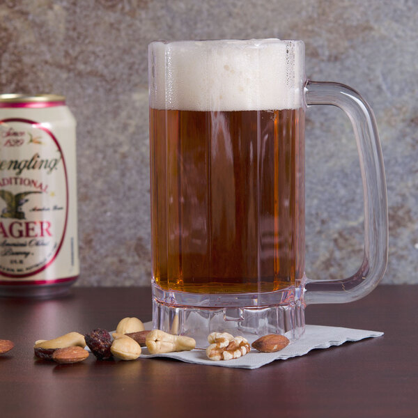 A customizable SAN plastic beer mug filled with beer on a counter with nuts.