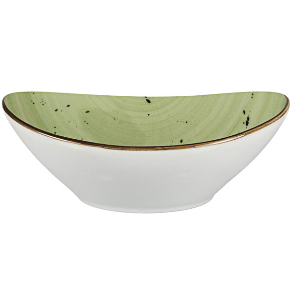An oval white porcelain bowl with a green rim.