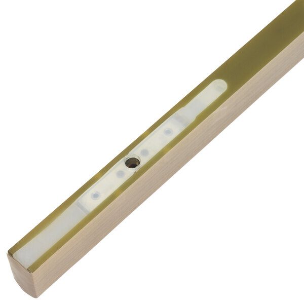 A gold metal strip with a white button on it.