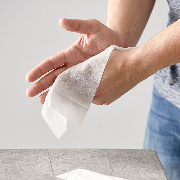 A person using a Fresh Towel to wipe their hands.