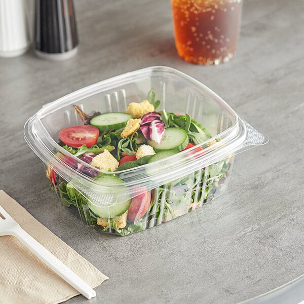 A salad in a Choice clear plastic deli container with a domed lid.