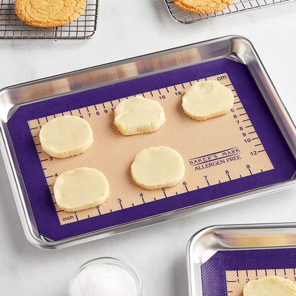 A Baker's Mark baking mat with cookies on a tray.