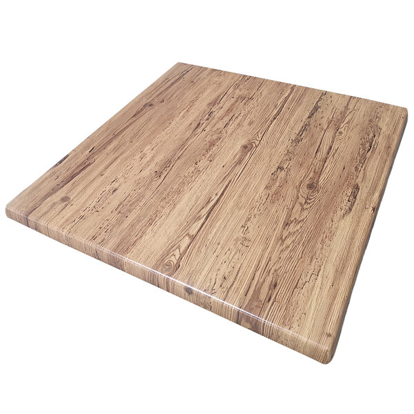 An American Tables & Seating square aged pine Isotop tabletop on a wood surface.
