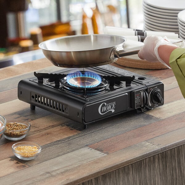 A person cooking with a Choice high performance butane portable stove.