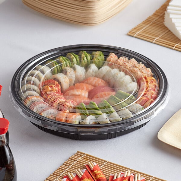 An Emperor's Select sushi tray with sushi and chopsticks on a table.