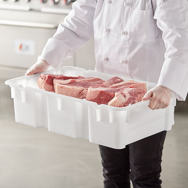 A person holding a white Choice agricultural crate filled with meat.