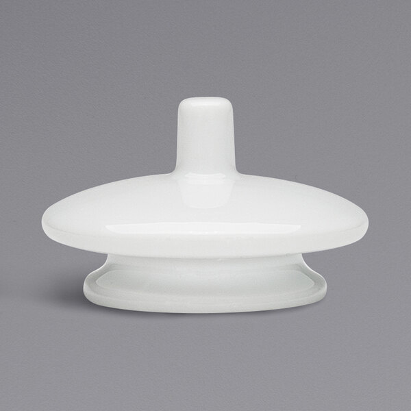 A white porcelain lid with a round top and a white plastic knob.