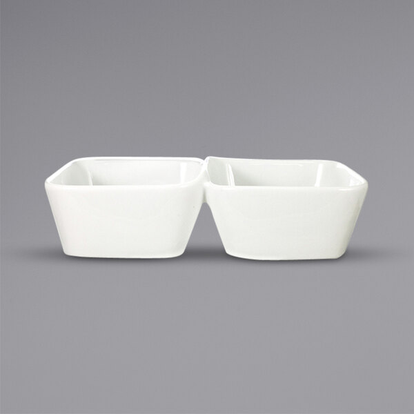 Two white square porcelain bowls with two compartments on a gray background.