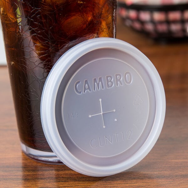 A translucent plastic lid with a straw slot on a drink in a glass.