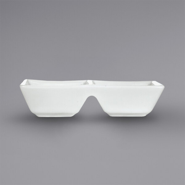 A white rectangular International Tableware sauce dish with two square wells.