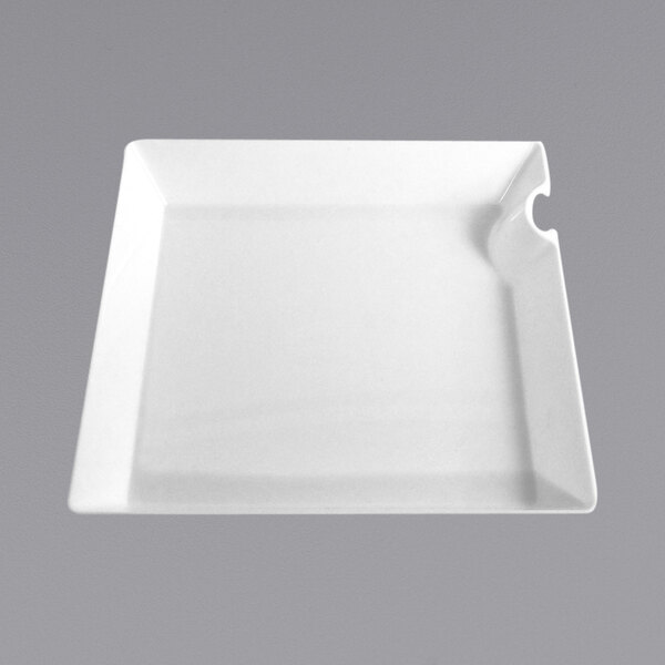A white Fineline square compostable plate with a utensil hanger on a white surface.