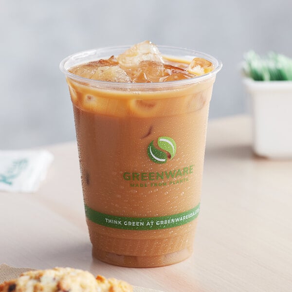 A Fabri-Kal Greenware plastic cup of iced coffee on a counter.