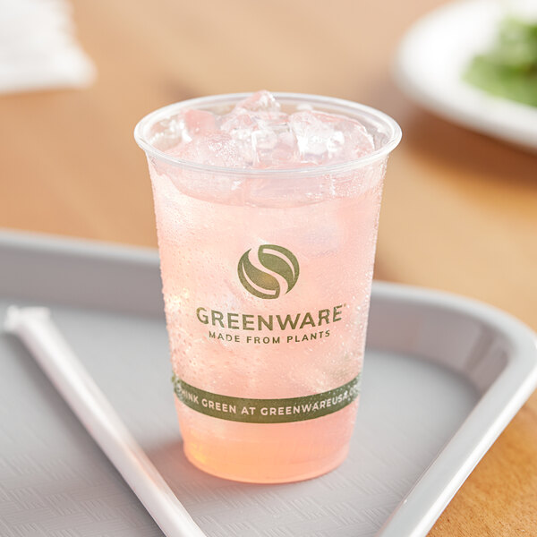 A Fabri-Kal Greenware plastic cup filled with pink liquid and a straw on a tray.