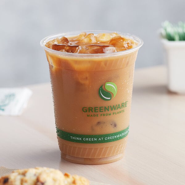 A Fabri-Kal Greenware plastic cup of iced coffee on a counter.