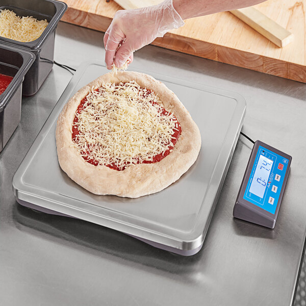 An AvaWeigh pizza scale weighing a pizza on a counter.