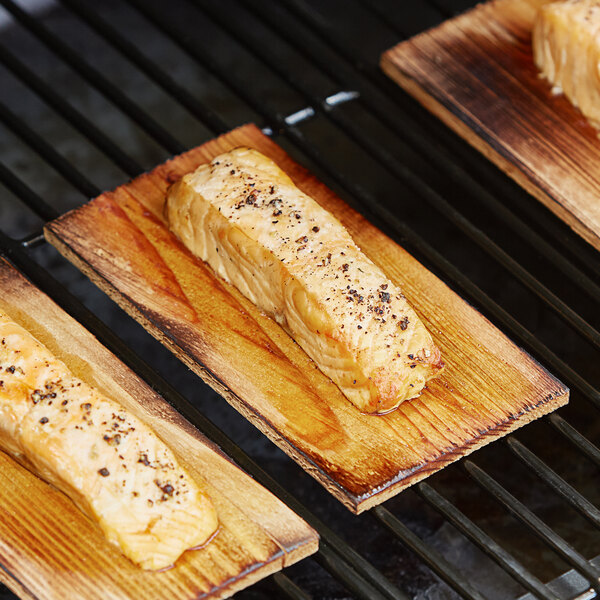 Rectangular pieces of salmon on a grill made with Cedar Wood Grilling Planks.