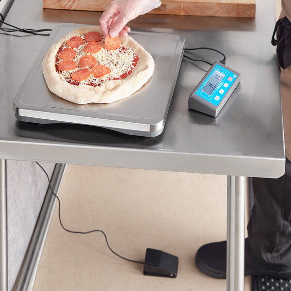 A person using an AvaWeigh pizza scale to weigh pepperoni on a pizza.