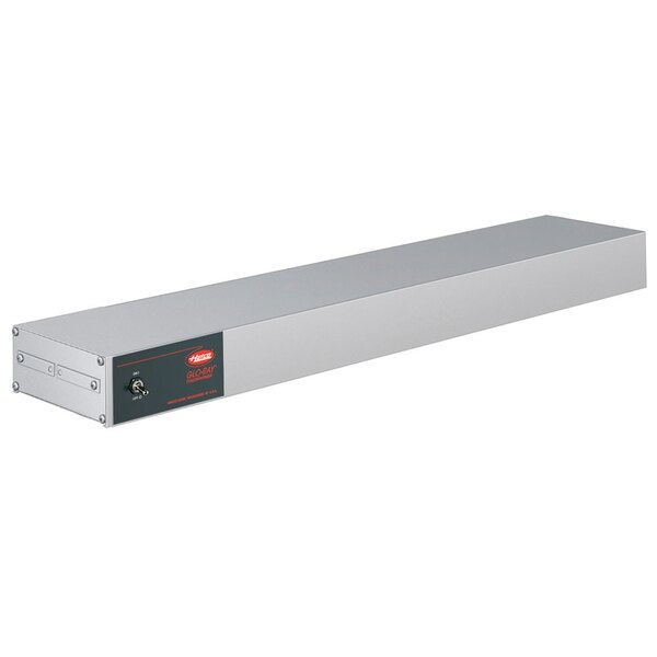 A long rectangular metal box with a black label and a red light.