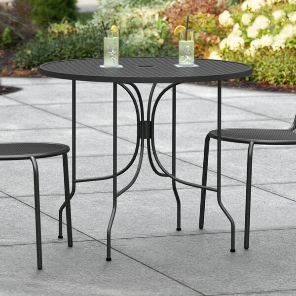 A black table and chairs on a patio.