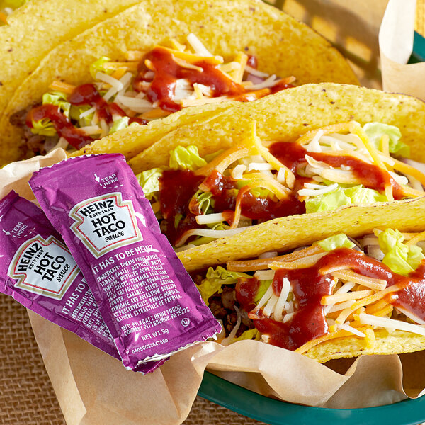 Tacos in a basket with Heinz Taco Sauce packets.