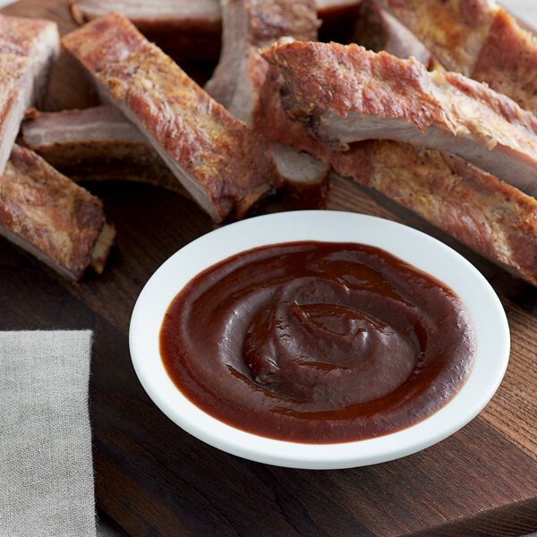A plate of ribs with Bull's-Eye Original BBQ Sauce next to a bowl of barbecue sauce.