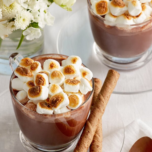 A mug of hot chocolate with Jet-Puffed mini marshmallows and a spoon.