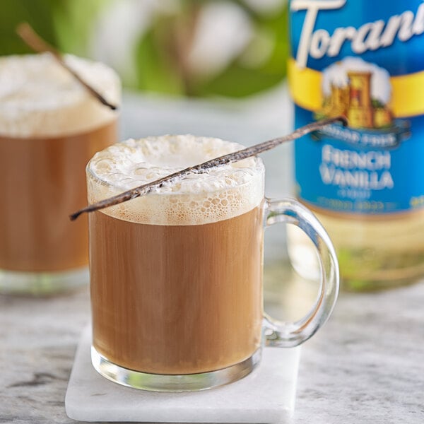 A glass mug of coffee with Torani Sugar-Free French Vanilla flavoring syrup on top.