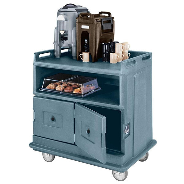 A slate blue Cambro beverage service cart with a door open holding a coffee machine and brown plastic container.