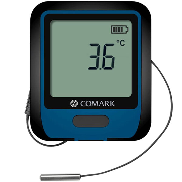 A Comark digital temperature data logger with a thermistor probe and wire on a counter.