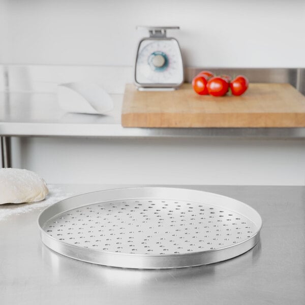 An American Metalcraft perforated tin-plated steel pizza pan with a white background.