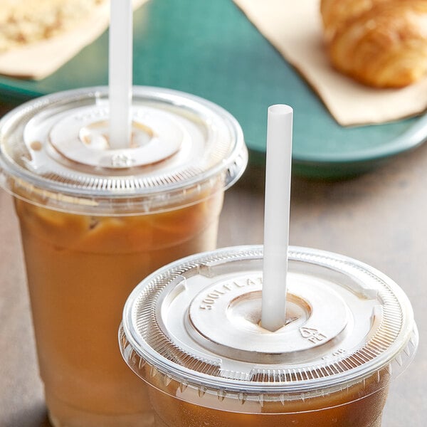Two plastic cups of iced coffee with EcoChoice straws and a croissant.