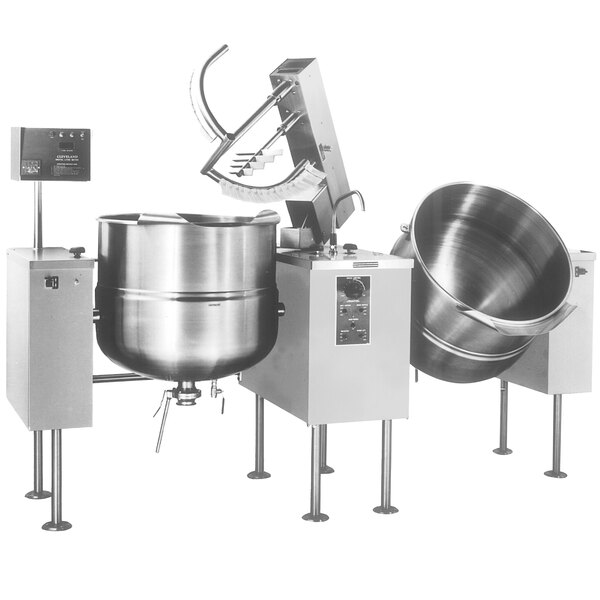 A Cleveland steam kettle with two tilting metal mixer bowls on top.