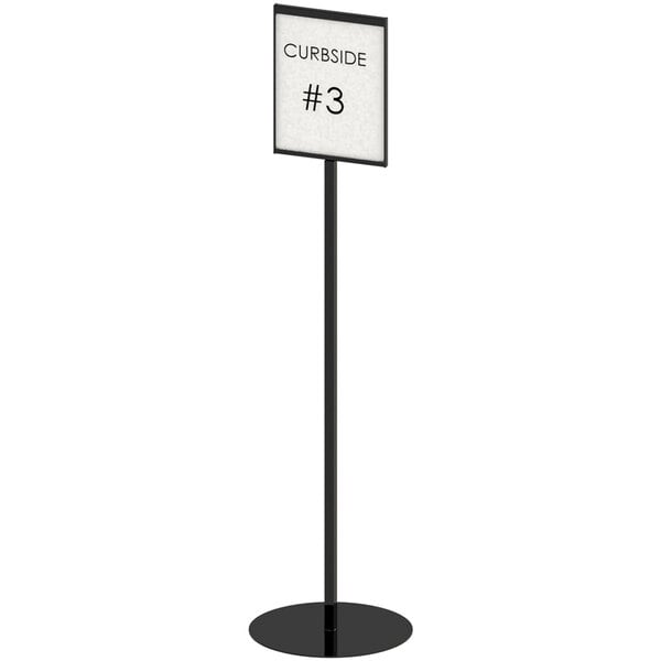 A black Cal-Mil free-standing sign holder with a white insert on a pole.