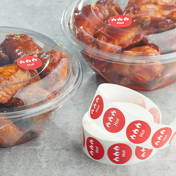 A group of plastic containers of chicken wings with Point Plus red labels on them.