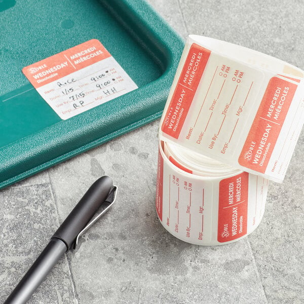 A roll of Noble Products Wednesday dissolvable food labels with a pen on a counter.