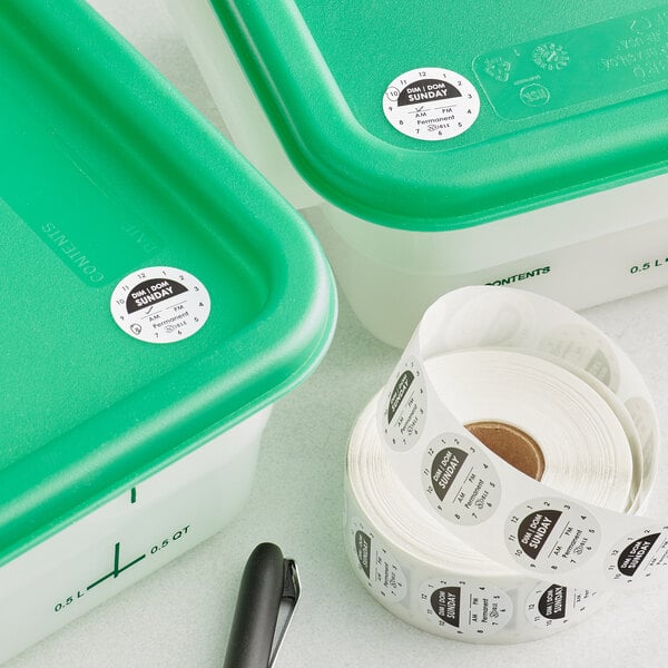 A roll of Noble Products Sunday day of the week labels on a green plastic container.