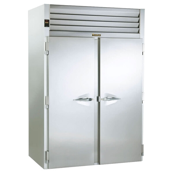 A large silver Traulsen roll-thru refrigerator with two open doors.