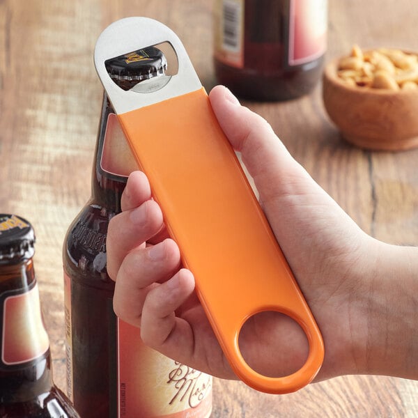 A person using an orange Choice bottle opener to open a brown bottle.