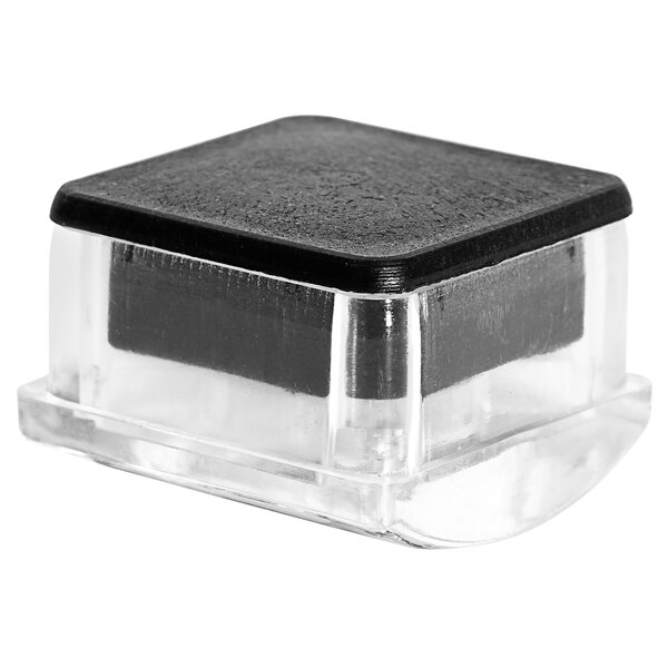 A clear plastic container with a black lid on the bottom of a chair leg.