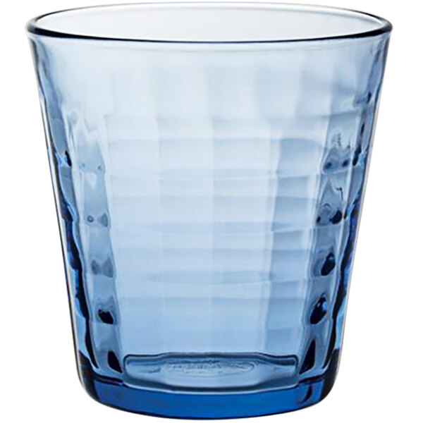 A blue Duralex glass tumbler with a pattern on it.