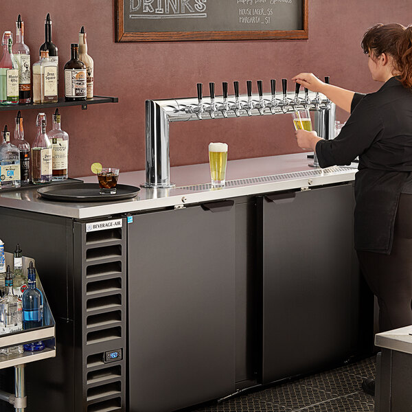 A woman pouring beer from a Beverage-Air kegerator.