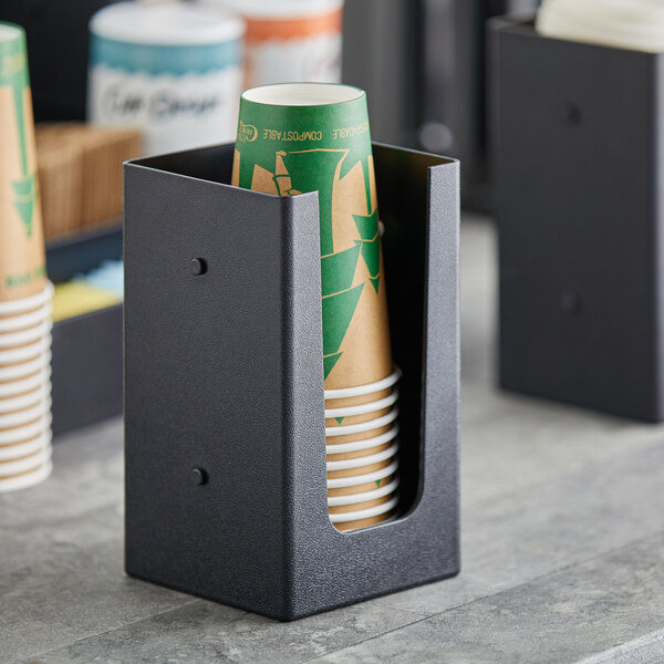 A black Choice countertop cup holder with cups in it.