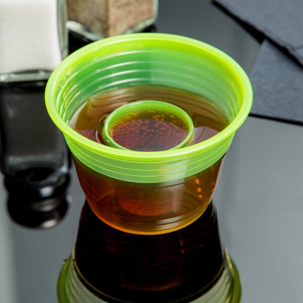 A yellow Fineline Quenchers Blaster Bomb shot cup with a drink inside.