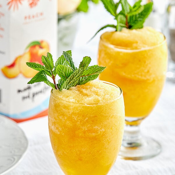 Two glasses of peach Island Oasis smoothie with mint leaves.