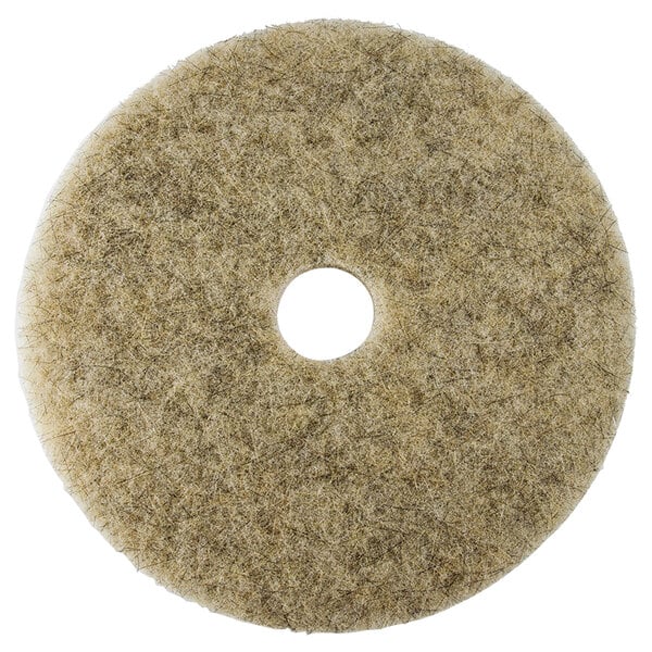A circular beige Scrubble by ACS medium burnishing floor pad with a hole in the middle.