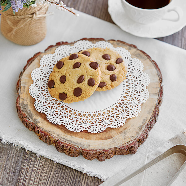 A wood platter with chocolate chip cookies on a Hoffmaster Cambridge lace doily.