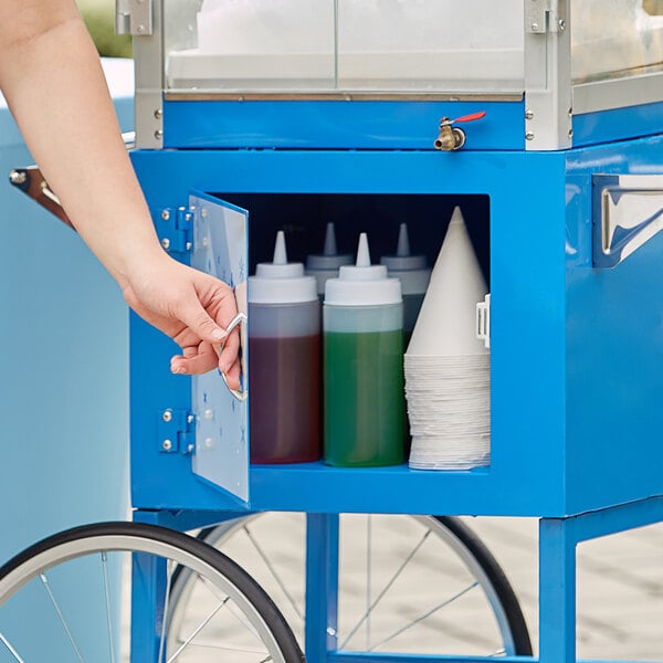 A hand opening a blue Carnival King cart for a Sno-Cone machine.