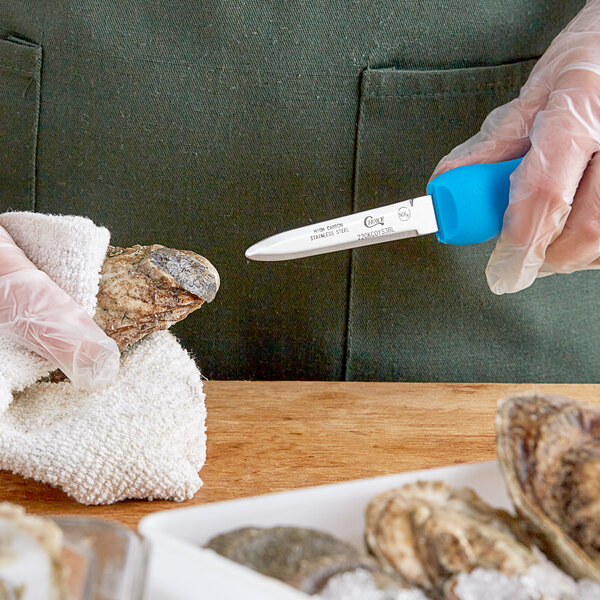A person using a Choice Boston style oyster knife to cut oysters.