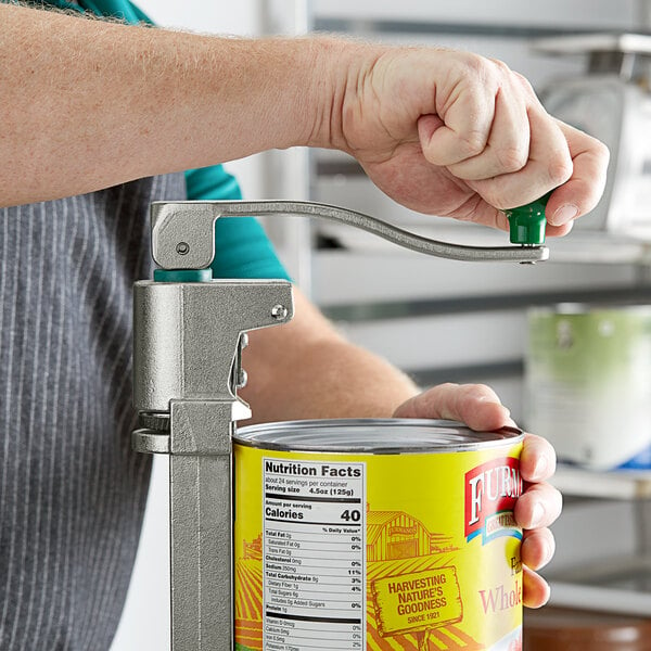 A person using a Garde heavy-duty manual can opener to open a can of food.
