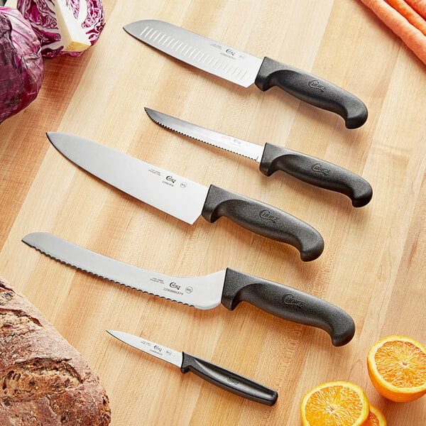 A group of Choice Essential knives with black handles on a table.